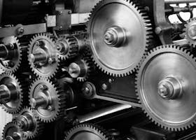 Close-up view of a complex industrial gear mechanism in black and white.