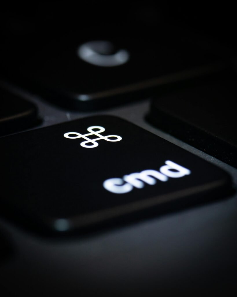 Macro photograph of a black computer keyboard's command key highlighting its symbol and text.