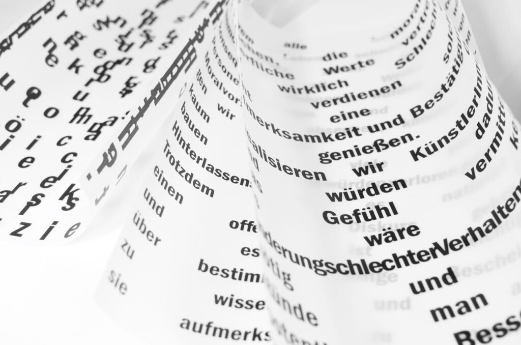 From above of white sheets of paper with curled edges and black written words placed on white background in light room